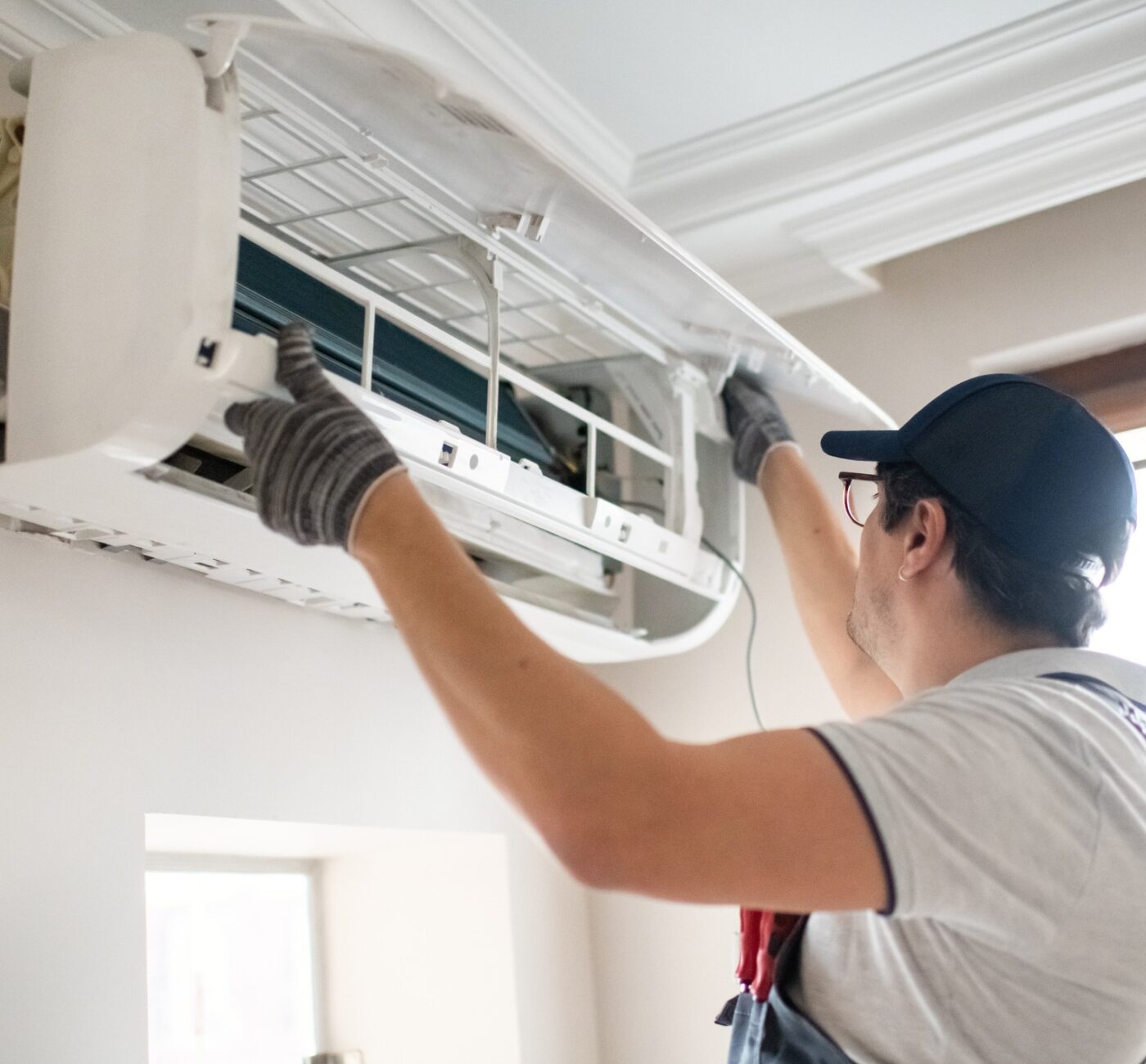 Technician repairing air conditioner at home air conditioning repairs dunmow