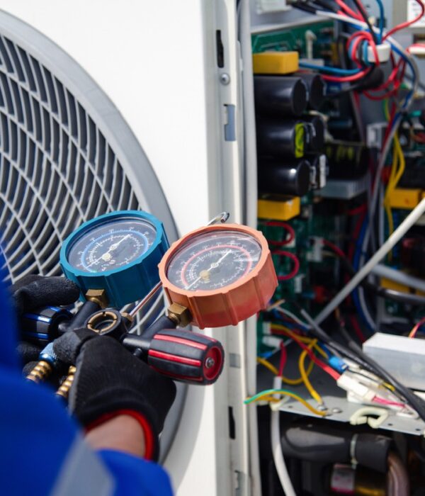 Air conditioner service .The air conditioner technician is using a gauge to measure the refrigerant pressure. air compressor. commercial heating hertfordshire